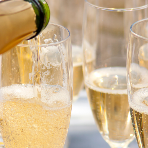 A close-up image shows champagne being poured into multiple flutes, suggesting a celebratory event or gathering.